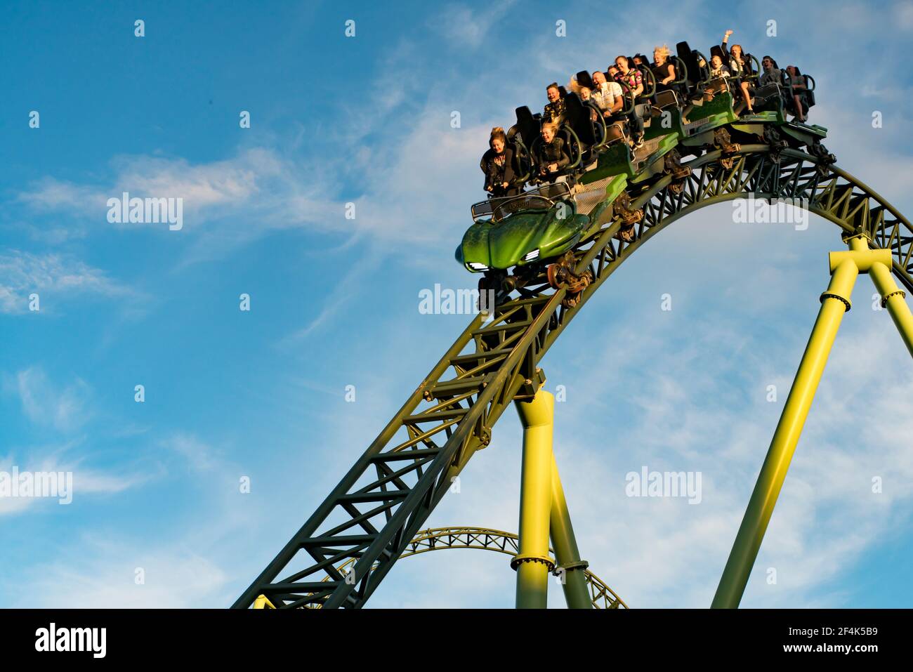 People screaming and holding up hands during roller coaster ride Helix Stock Photo