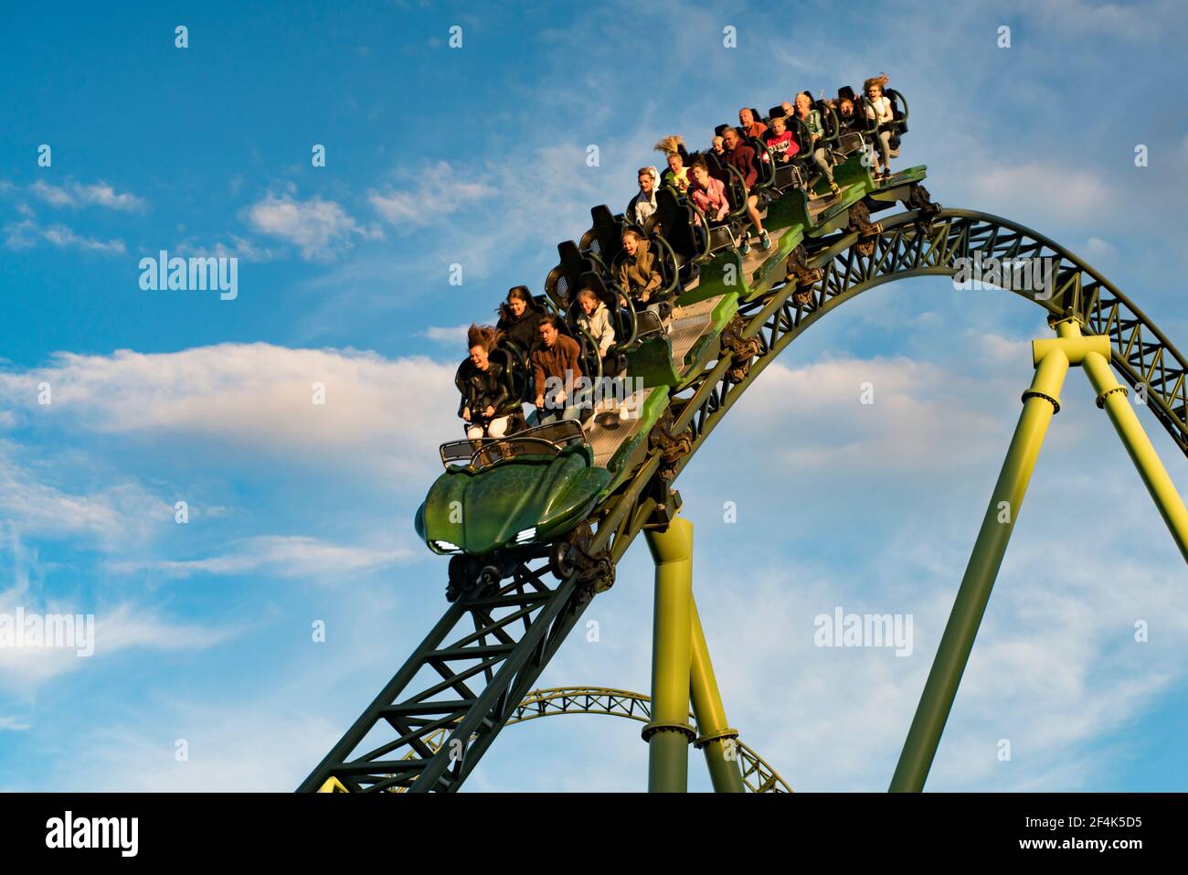 People screaming and holding up hands during roller coaster ride Helix Stock Photo