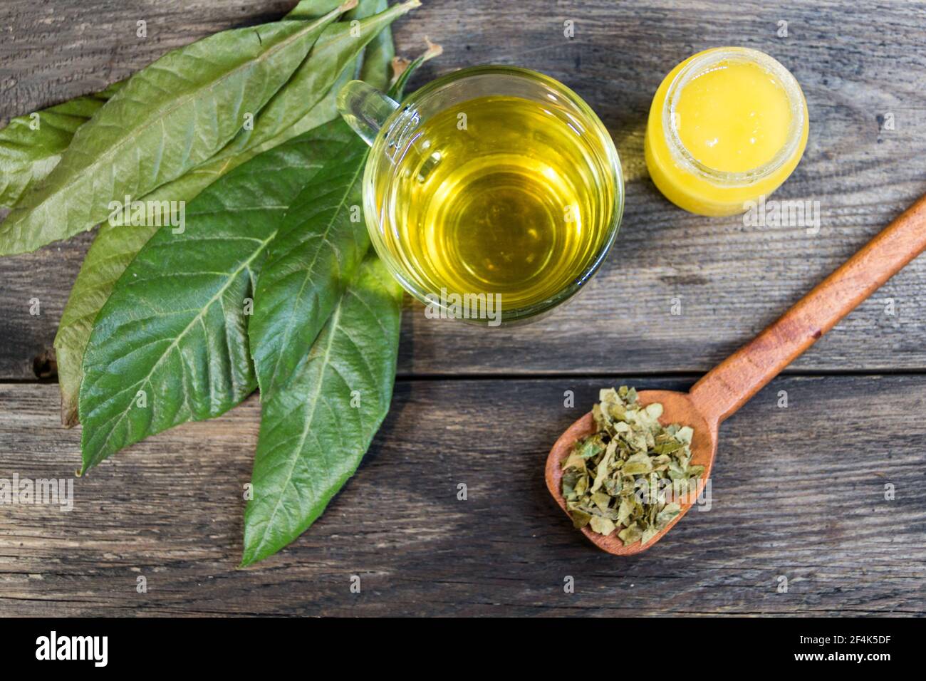 medicinal infusion of loquat leaves with honey, on rustic wooden background Stock Photo