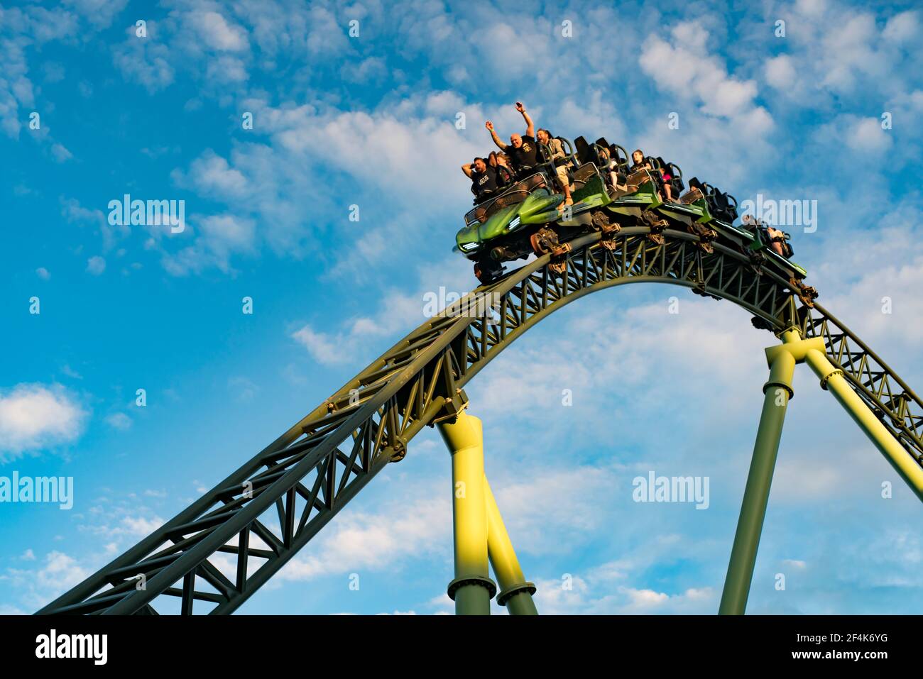 People screaming and holding up hands during roller coaster ride Helix Stock Photo