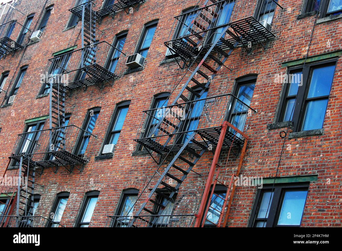 The outside wall of an apartment block featuring fire escapes in New York City Stock Photo