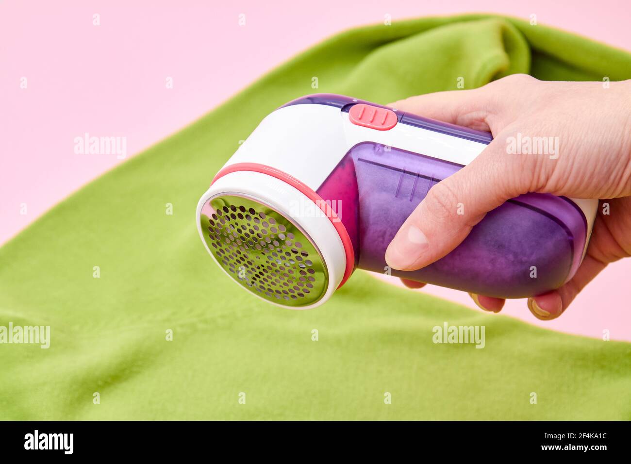 A wooman using Fabric shaver removes fabric pills from garments. Close-up, selective focus Stock Photo