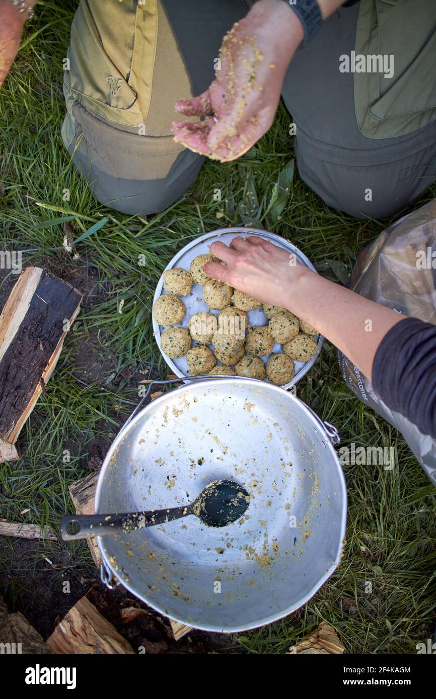two people making meatballs outdoors during camping Stock Photo Alamy