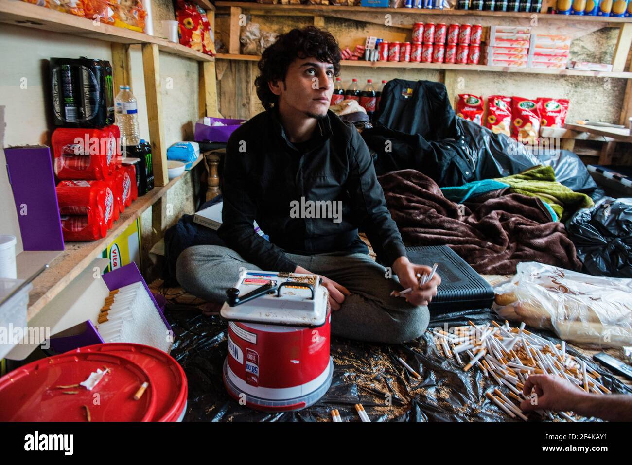 Calais, France, Illegal migrant producing and selling home made cigarettes for a dime a piece. Stock Photo