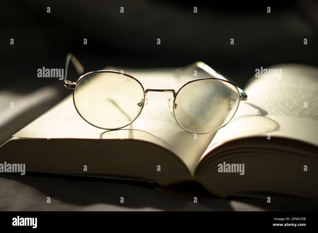 wisdown and knowledge. reading a book. eyeglasses laid up on a book. Stock Photo