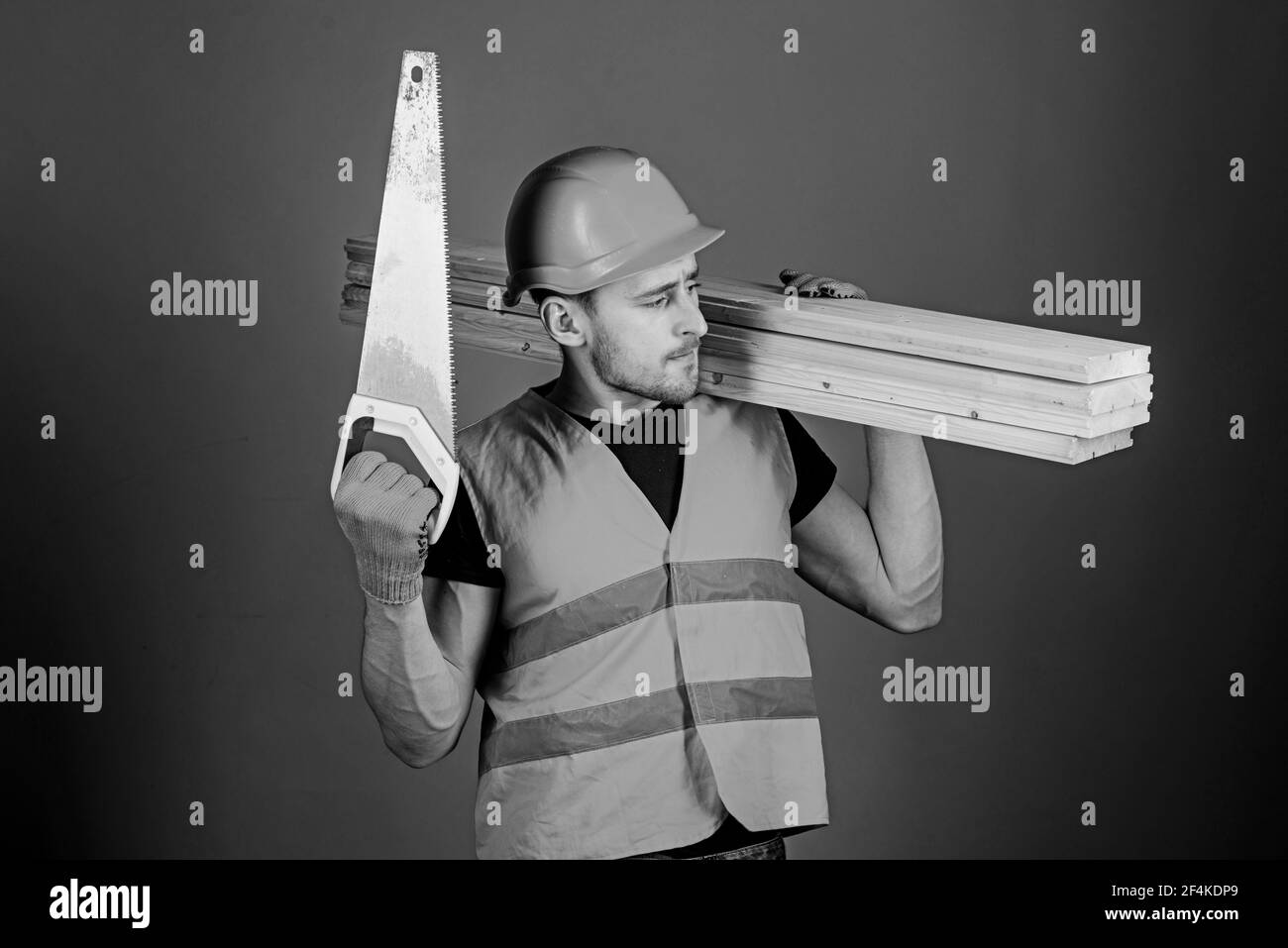 Woodcraft concept. Man, handyman in helmet, hard hat holds handsaw and