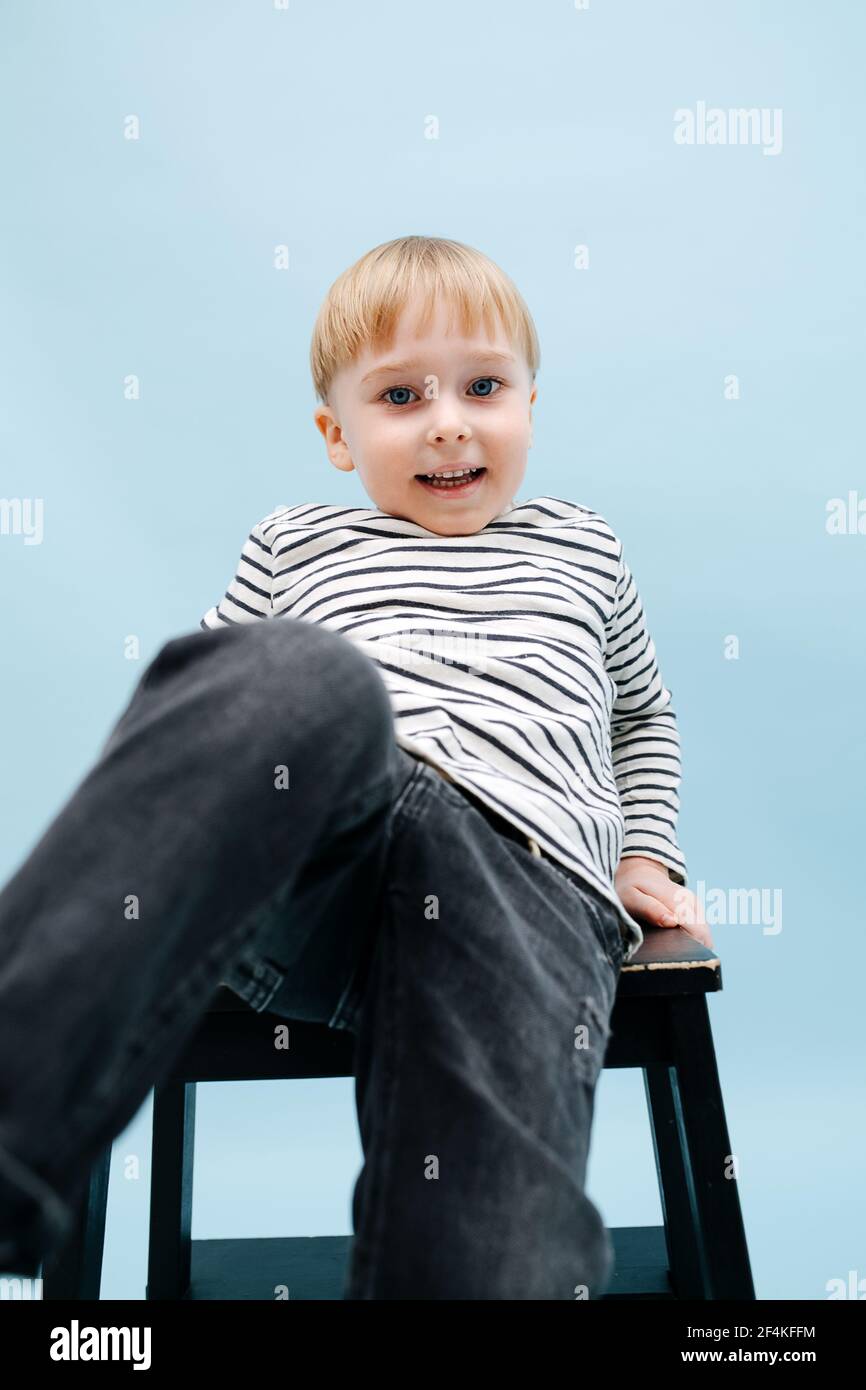 Boy sitting on stool hi-res stock photography and images - Alamy
