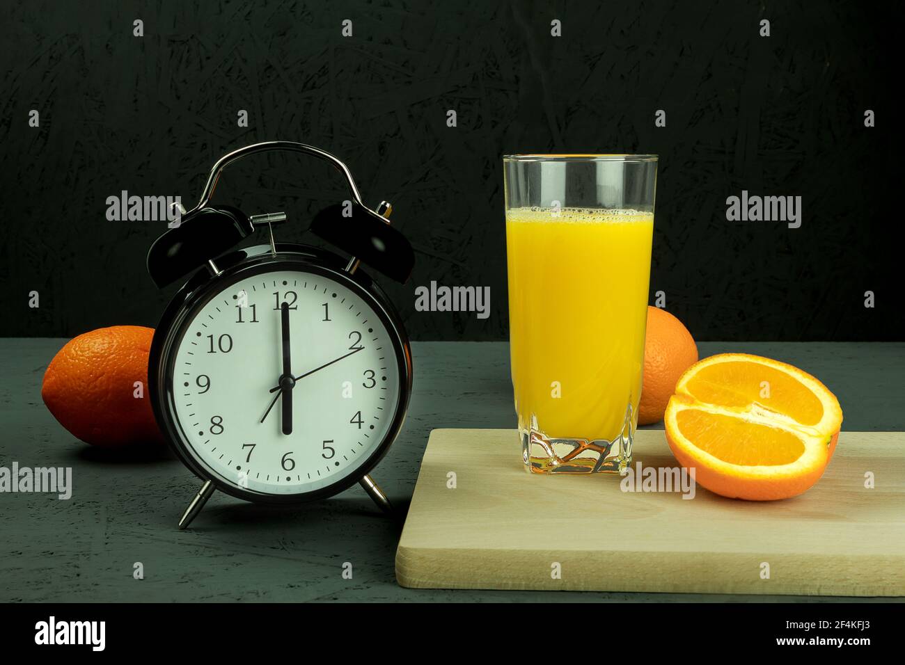 Alarm clock at which six o'clock in the morning. Black clock and orange juice. Time 600 am