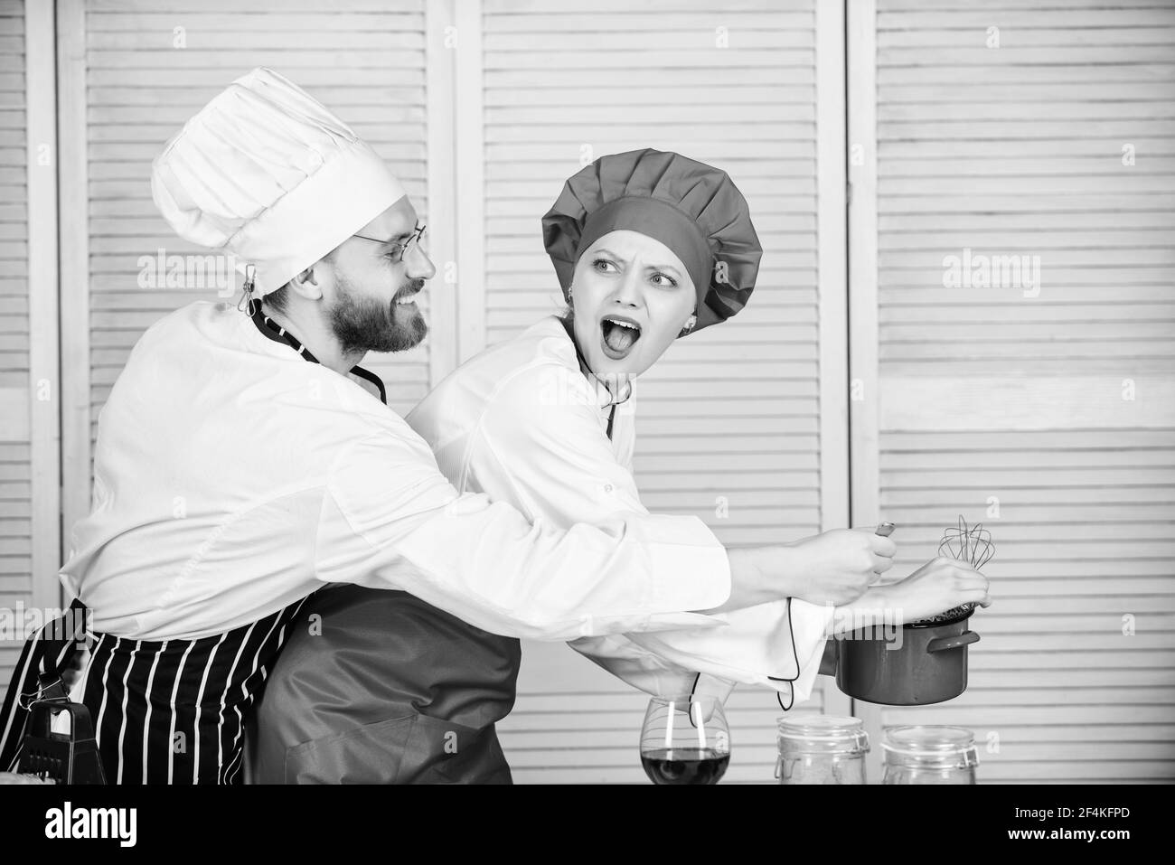 Woman and bearded man chef cooking together. Delicious meal. Baking pie together. Cooking together is more fun. Let my try taste. Couple having fun Stock Photo