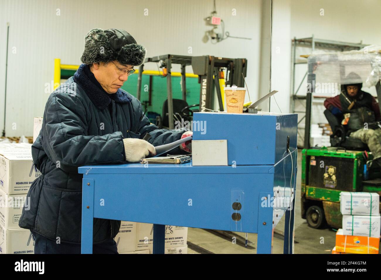 New York City, USA. Wholesale market stall employee crunching the