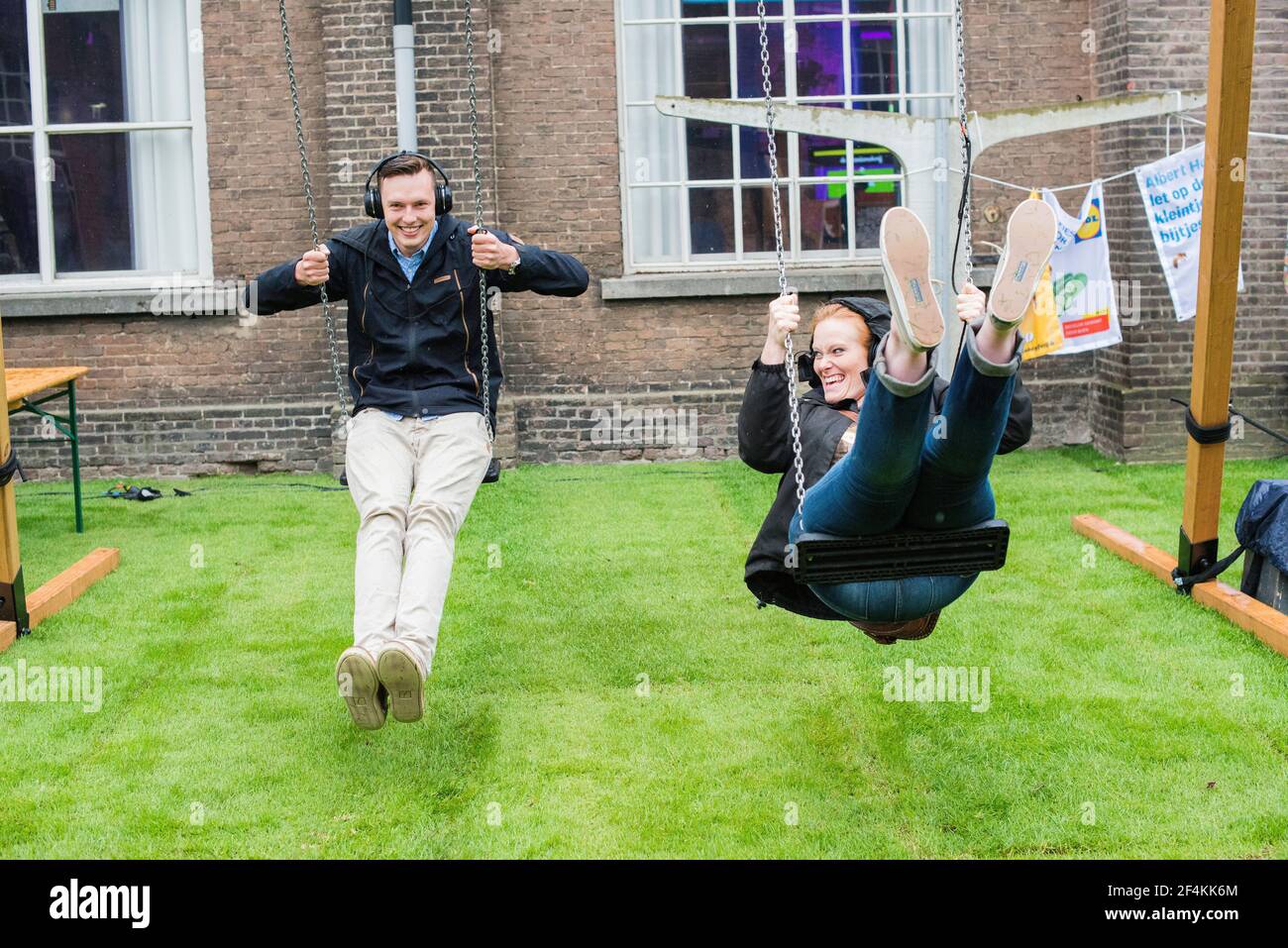 Tilburg, Nederland. Twee bezoekers van Festival Mundial 2016 leven zich uit op schommels. Tilburg, Netherlands. Two visitors to Festival Mundial 2016 enjoying themselves on a pair of swings. Stock Photo