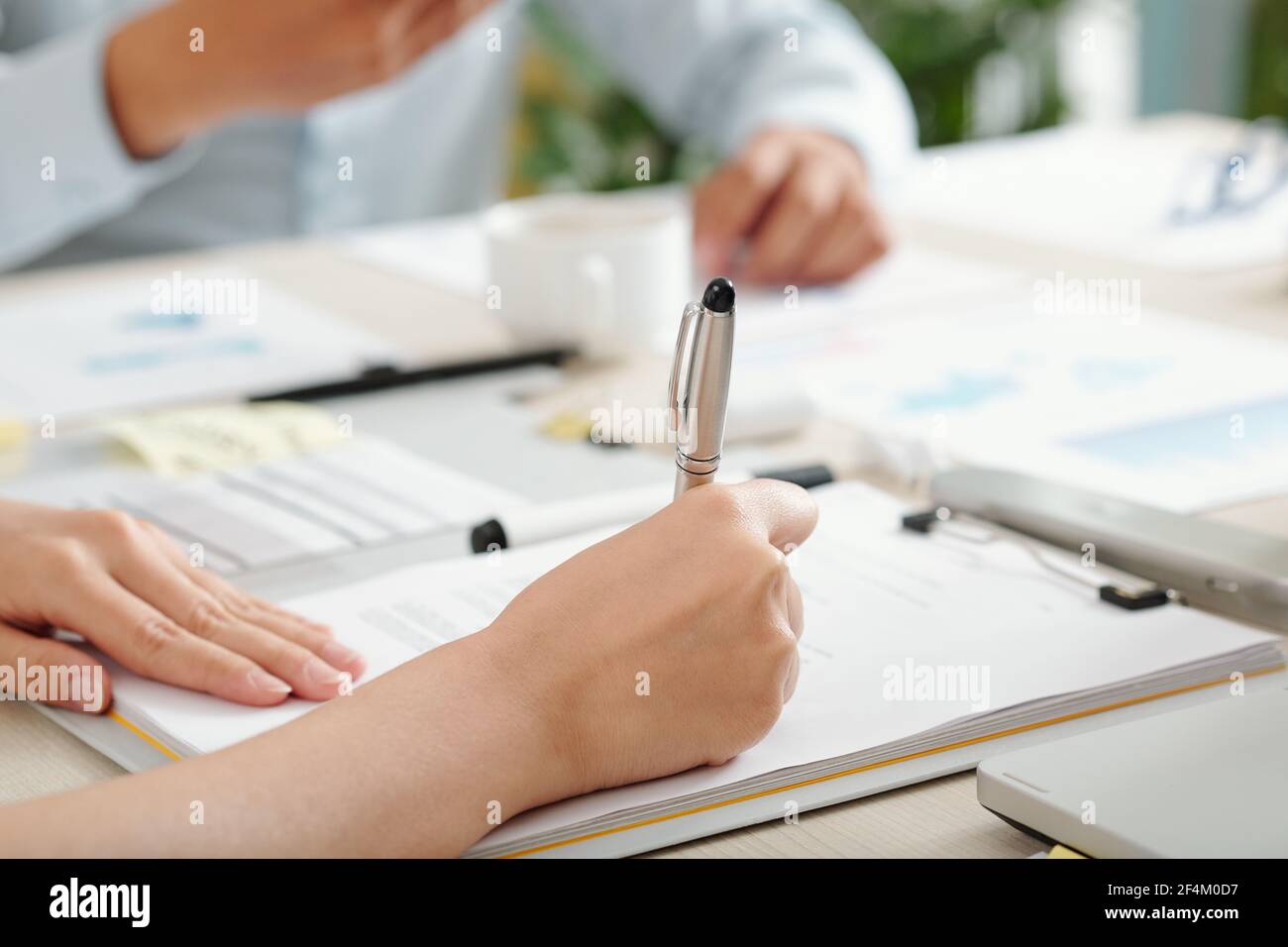 Close-up image of female entrepreneur singing agreement at meeting with business partner Stock Photo