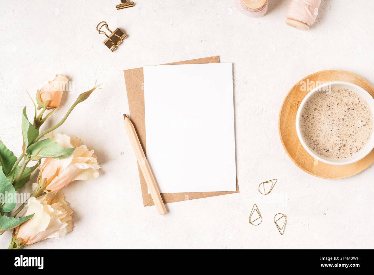 Blank white card with craft paper envelope in hands Stock Photo
