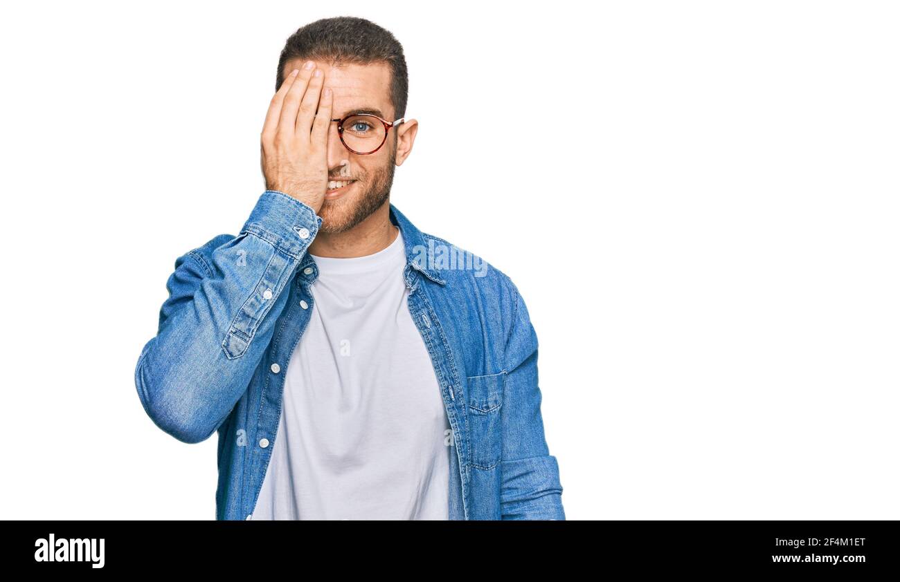 Young caucasian man wearing casual clothes covering one eye with hand ...