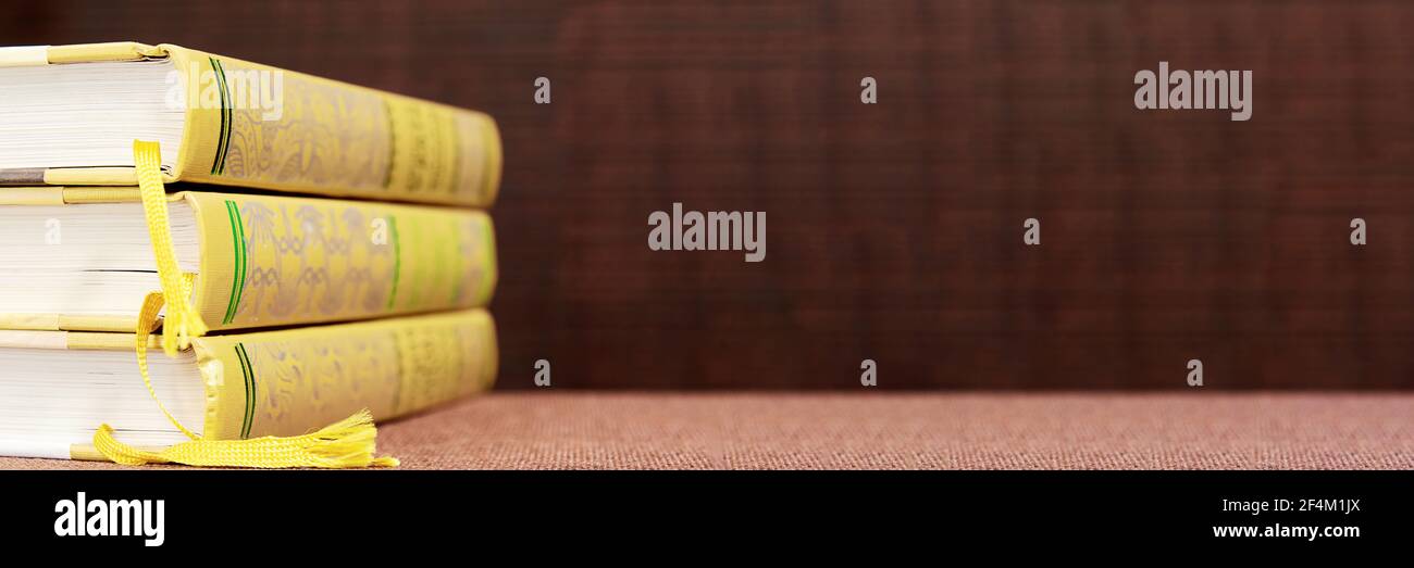 Banner with wide bookshelf and a stack of hardcovered books with ...