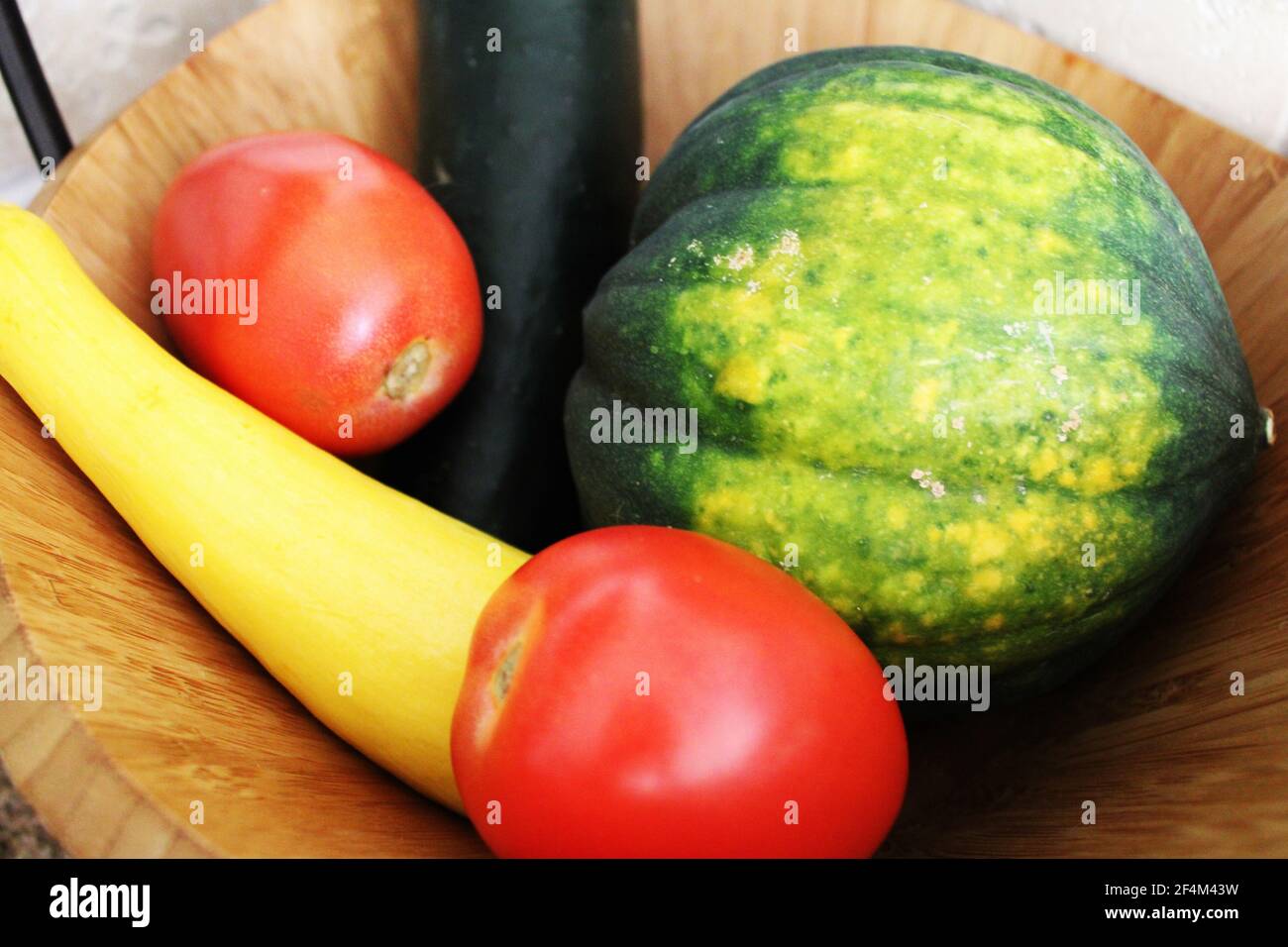 colorful fresh produce in wooden bowl Stock Photo