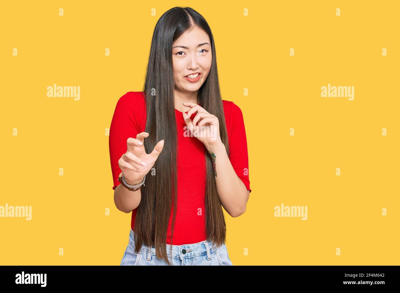 Young chinese woman wearing casual clothes disgusted expression, displeased and fearful doing disgust face because aversion reaction. with hands raise Stock Photo