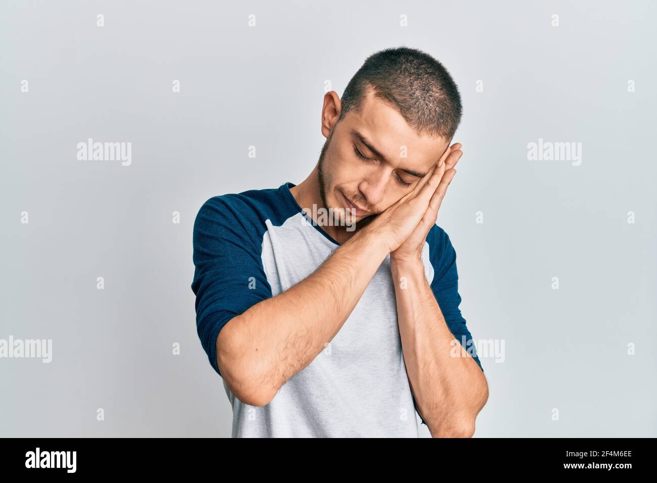 Hispanic young man wearing casual clothes sleeping tired dreaming and ...