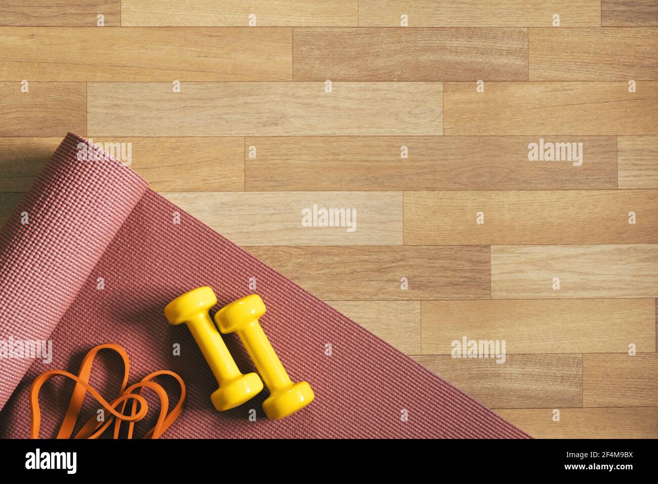 Training, being fit at home in lockdown. Yoga mat, fitness gum and barbells on the floor, top view Stock Photo