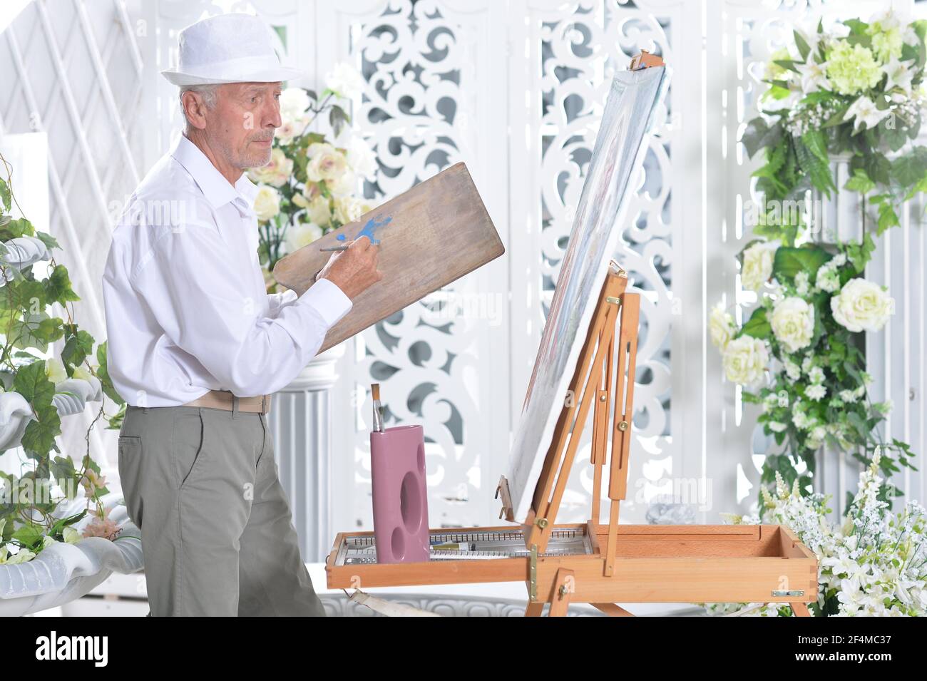 Portrait of elderly man painting with easel Stock Photo - Alamy