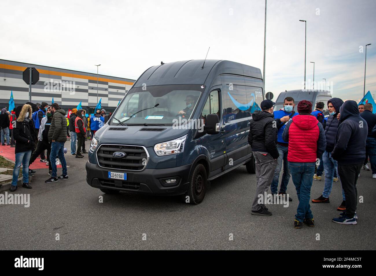 Brandizzo, Italy - 22 March, 2021: A delivery truck passes close to demonstrators during a demonstration for better working conditions in front of the Amazon distribution centre in Brandizzo. Trade unions said that 9,500 warehouse workers and 15,000 drivers were on strike in Italy. Credit: Nicolò Campo/Alamy Live News Stock Photo