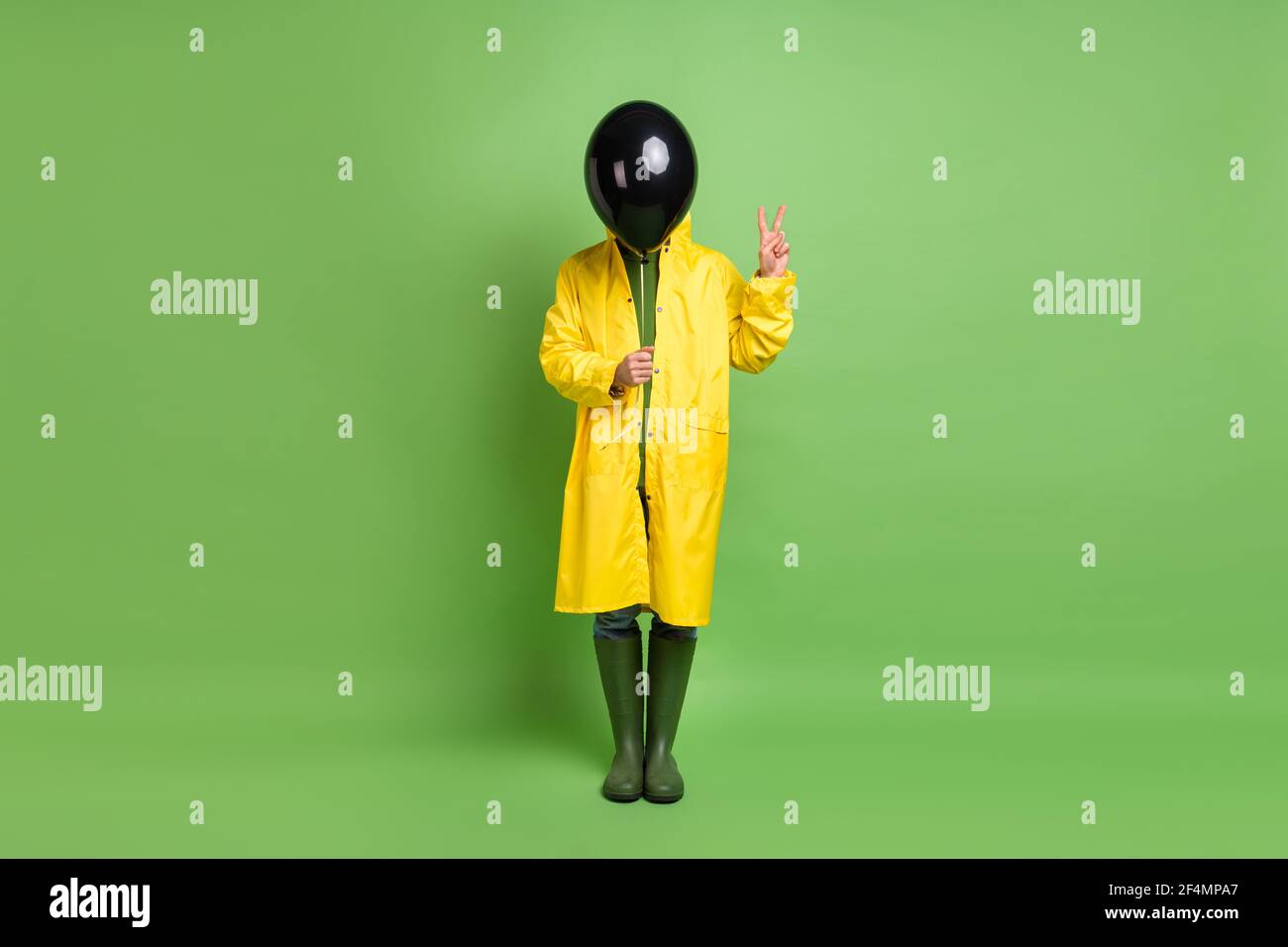 Full length photo of young man incognito cover face air balloon show peace cool v-sign isolated over green color background Stock Photo
