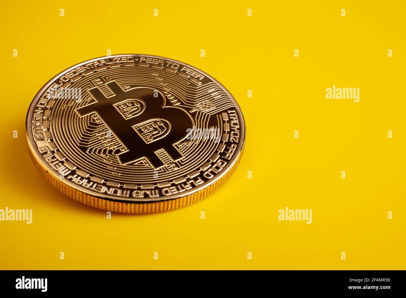 Golden bitcoin on a yellow background Stock Photo