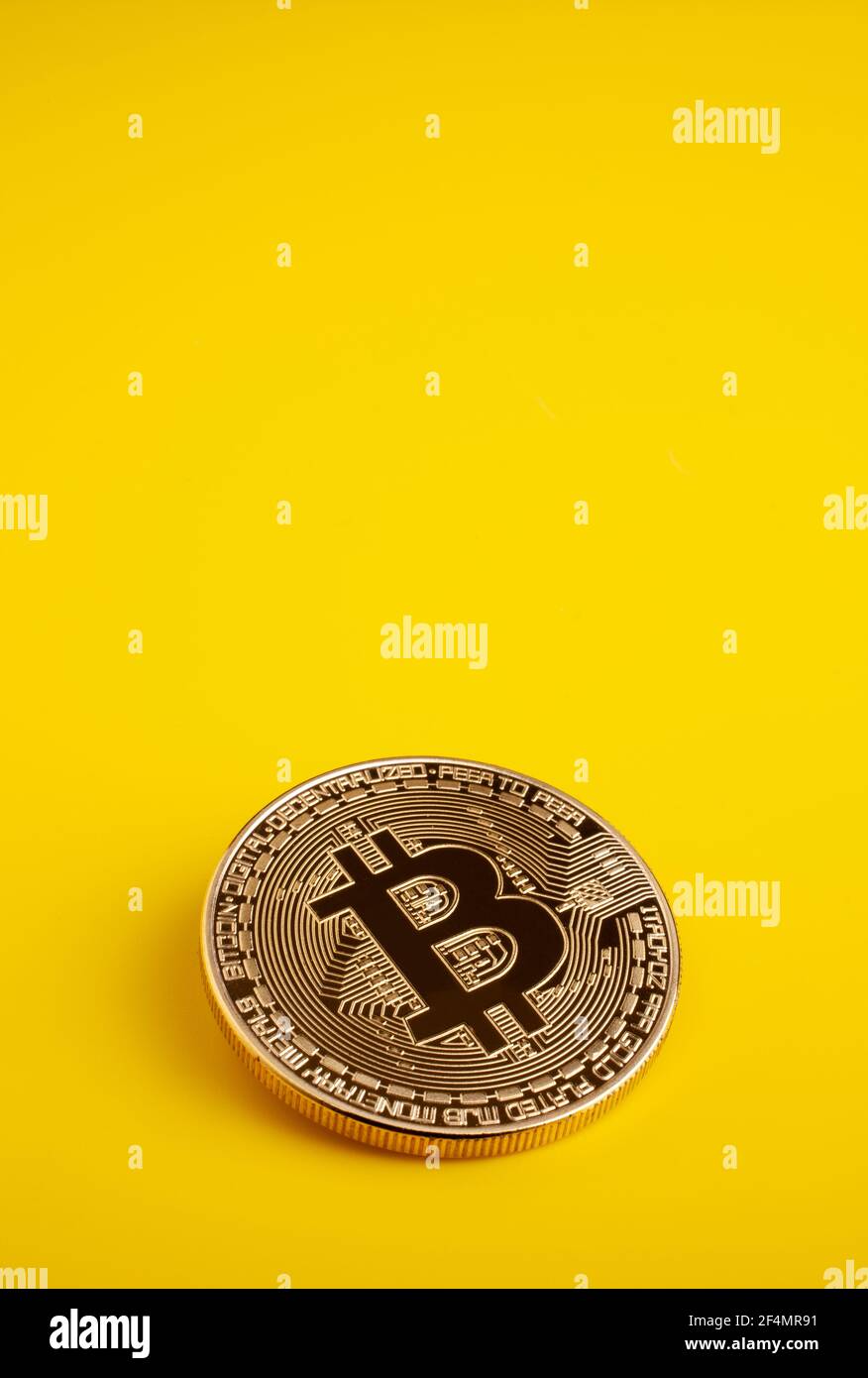 Golden bitcoin on a yellow background Stock Photo