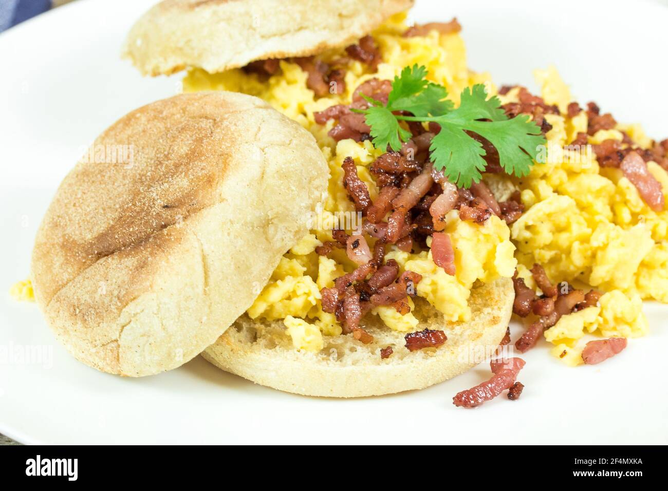 bun, scrambled egg and bacon on a plate Stock Photo Alamy