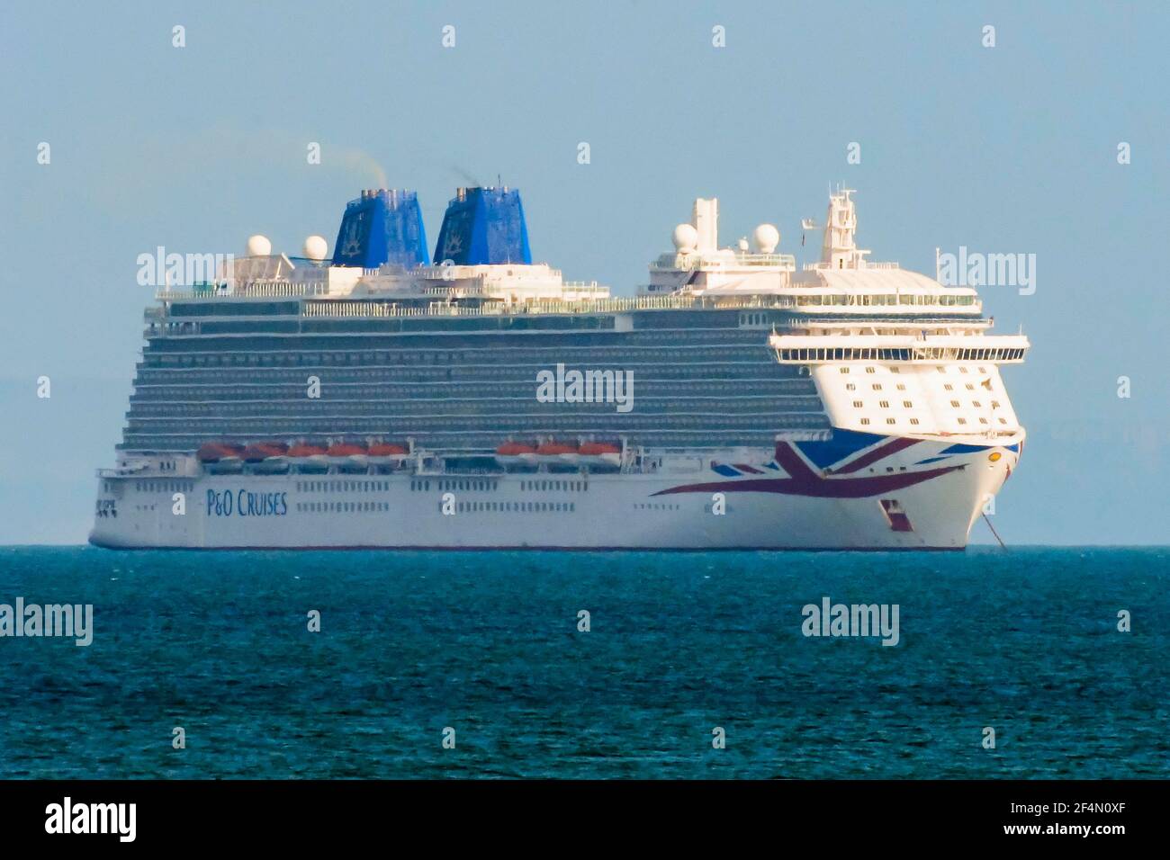 Weymouth, Dorset, UK.  22nd March 2021.  UK Weather.  The empty P&O cruise ship Britannia anchored in the bay at Weymouth in Dorset during the Covid-19 lockdown.  Picture Credit: Graham Hunt/Alamy Live News Stock Photo