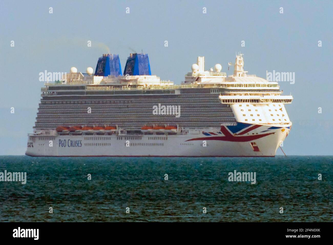 Weymouth, Dorset, UK.  22nd March 2021.  UK Weather.  The empty P&O cruise ship Britannia anchored in the bay at Weymouth in Dorset during the Covid-19 lockdown.  Picture Credit: Graham Hunt/Alamy Live News Stock Photo