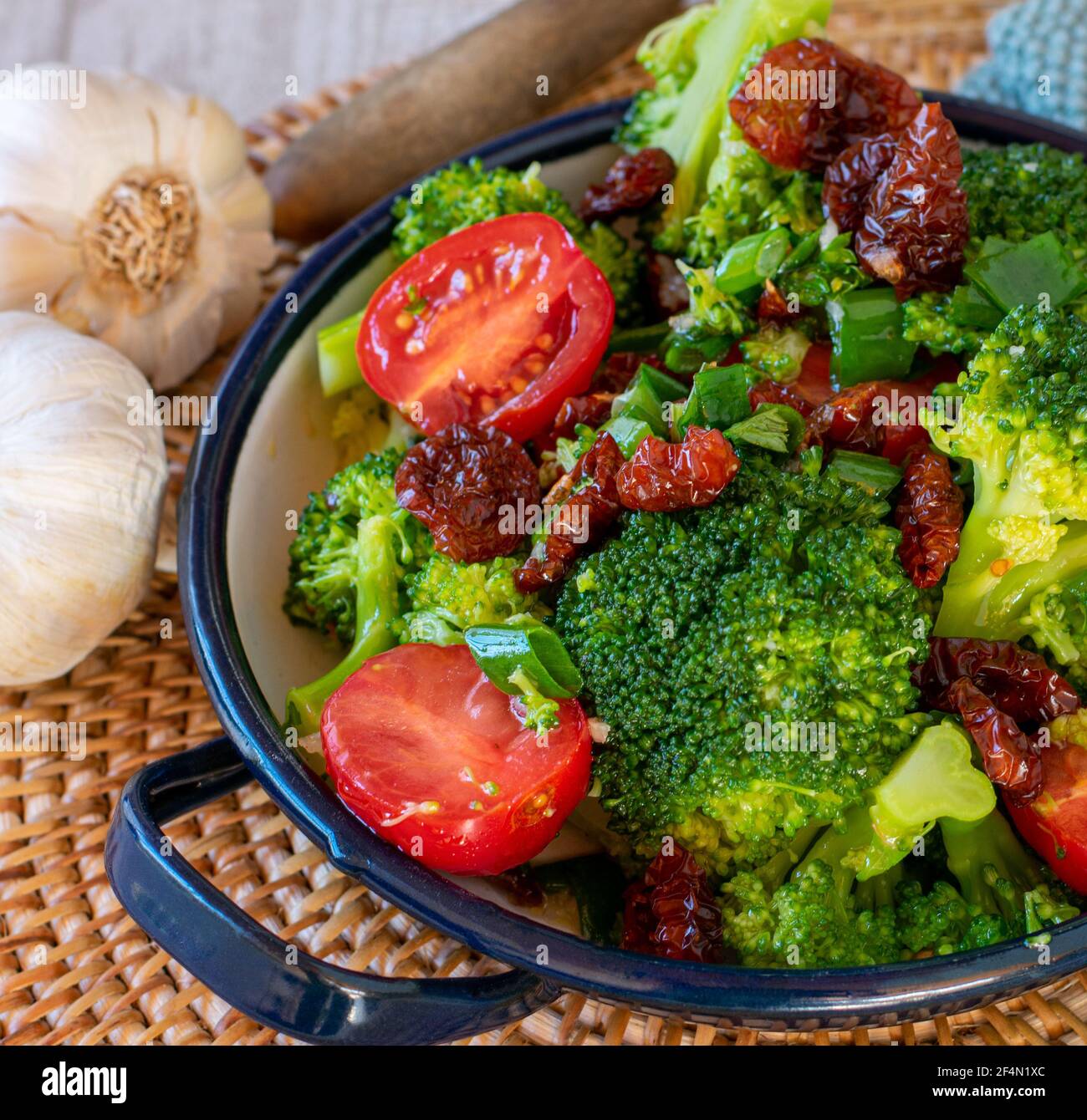 mediterranean salad with steamed broccoli florets, dry and fresh tomatoes, onion, garlic in a balsamic, olive oil dressing Stock Photo
