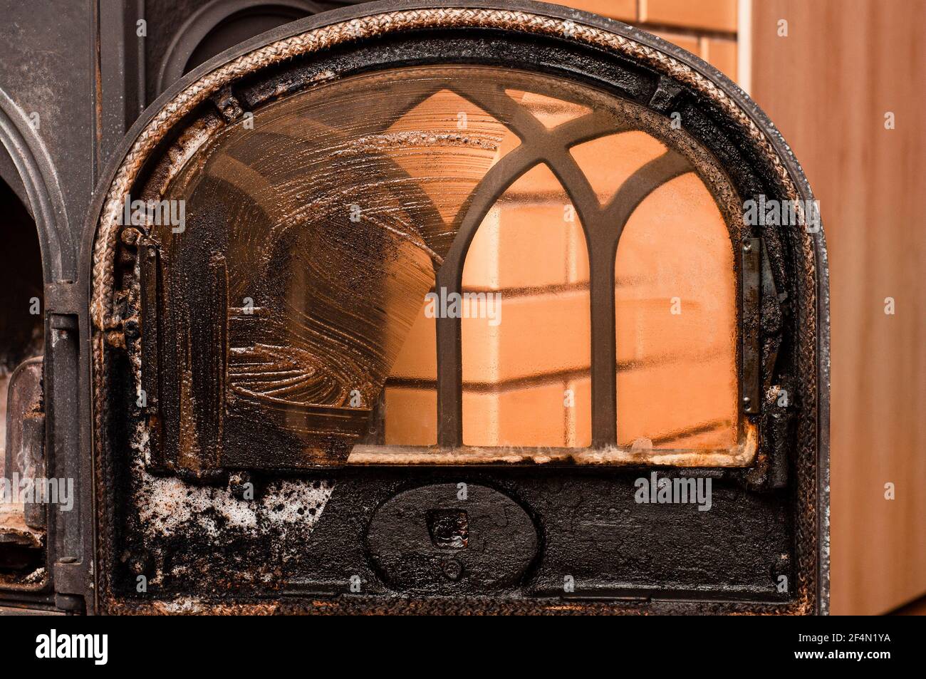 Photo of a fireplace window after washing off the detergent. Corrosive detergent effect Stock Photo
