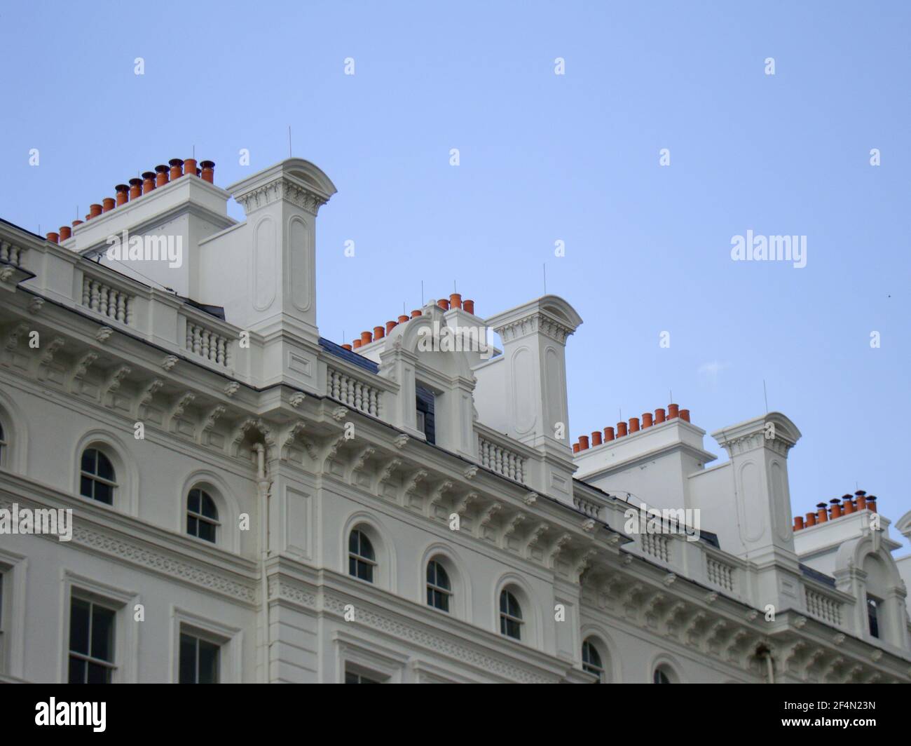 very elegant and ornate roofline of whitewashed mansions showing rows of chimney pots  Stock Photo