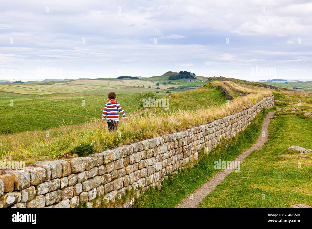 A small boy on Hadrians Wall at Steel Rig, Northumberland UK - NB Image No. C61BT4 shows his father at the same spot at the same age 31 years earlier.. Stock Photo