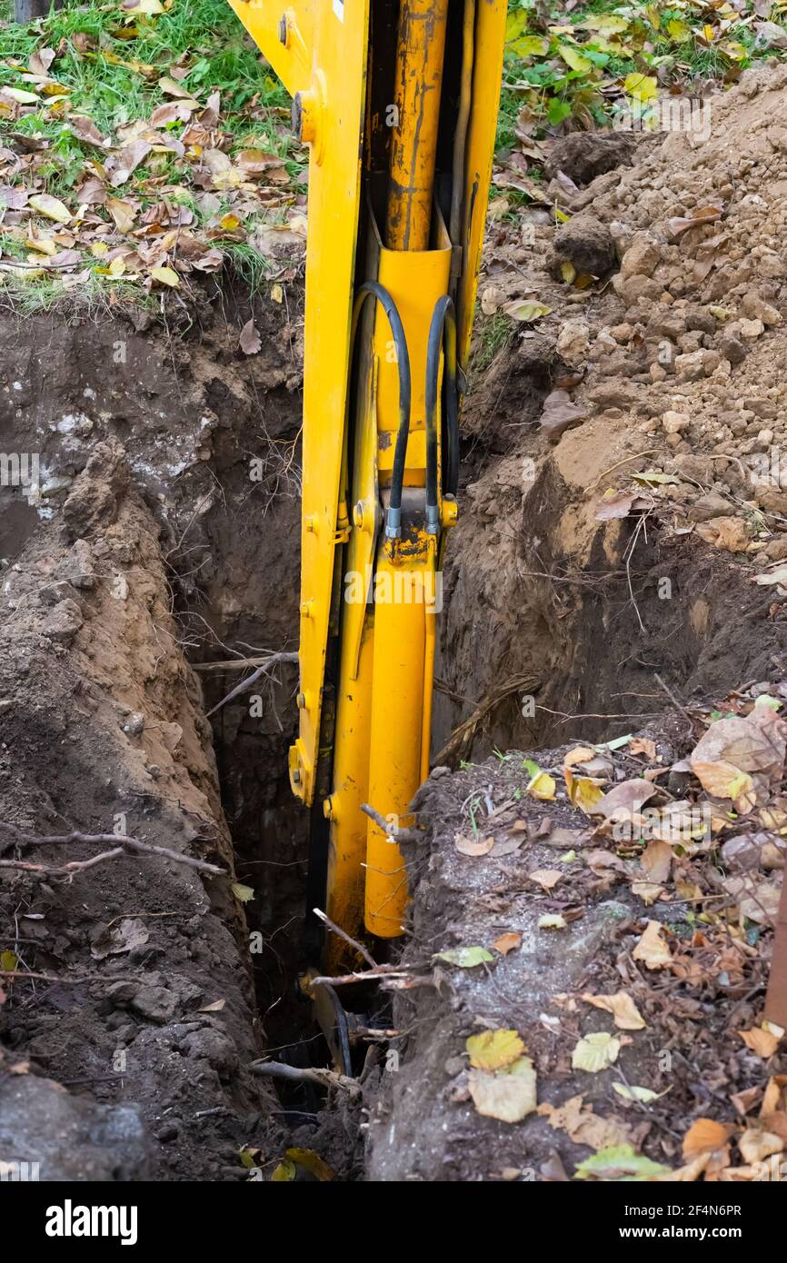 The excavator digs a hole for a septic tank. Working the machine with the ground. Stock Photo