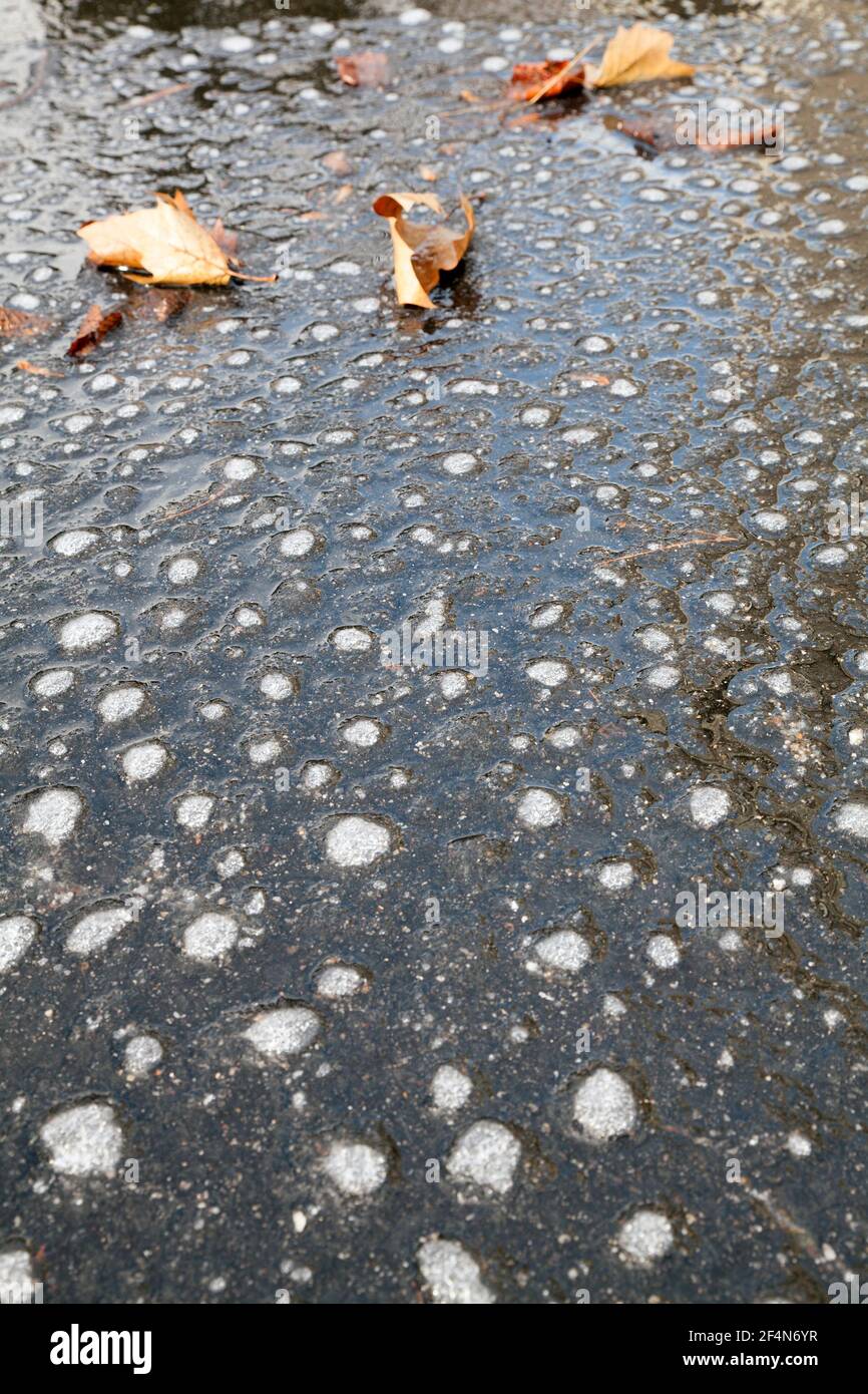 Strange dots on a sheet of ice on asphalt. Stock Photo