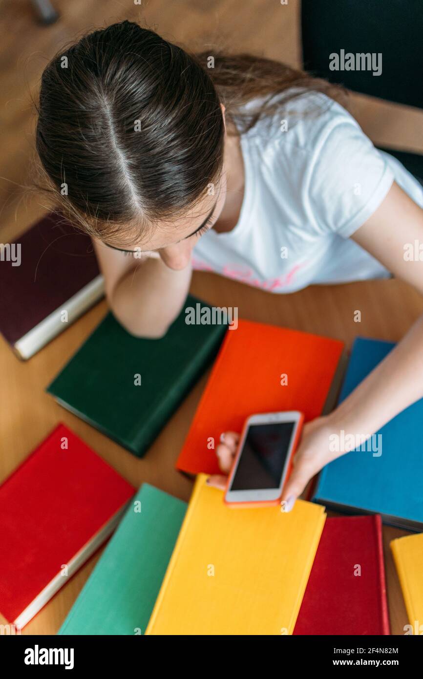 Back to school library concept. Student girl holding book on her head ...