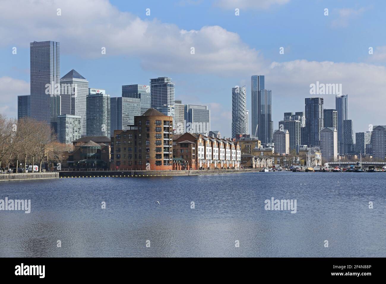 Waterfront housing in Greenland Dock, Rotherhithe, London, UK. Part of the  old Surrey Docks redeveloped in the 1980s. Canary Wharf towers beyond. Stock Photo