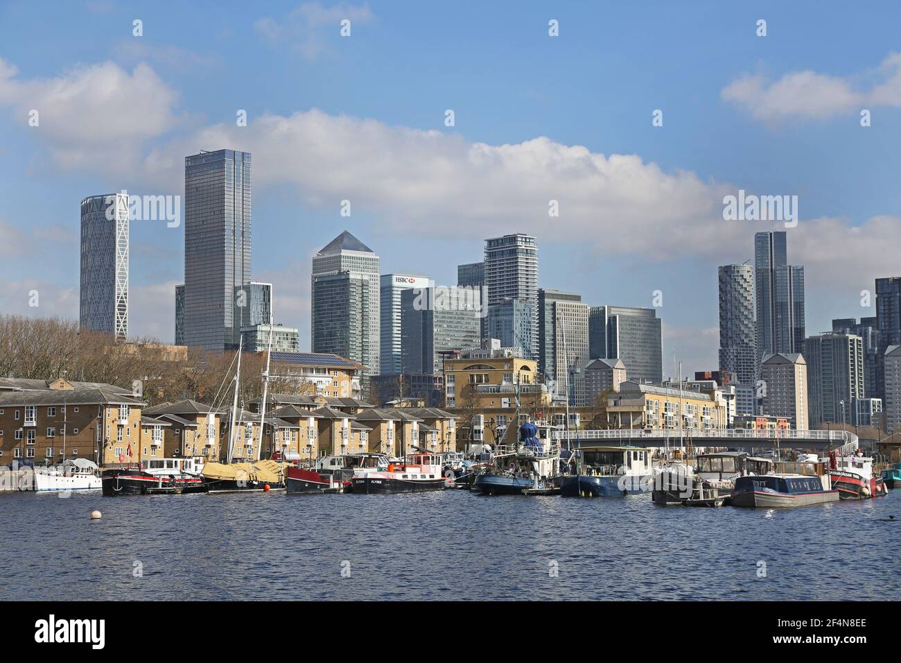 Houseboats in Greenland Dock, Rotherhithe, London, UK. Part of the  old Surrey Docks redeveloped in the 1980s. Canary Wharf towers in the background. Stock Photo