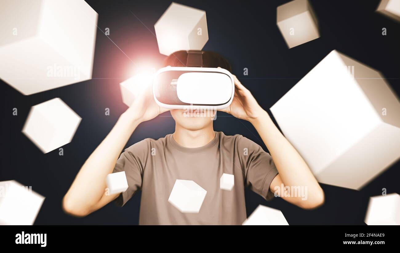 Man wearing glasses of virtual reality headset (VR) using with smartphone and playing box game. Concept of future technology. Stock Photo