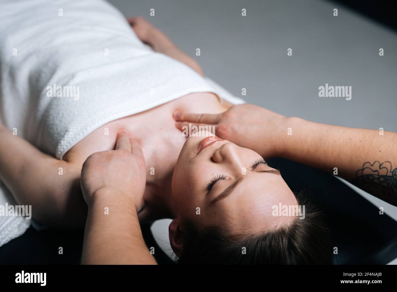 Close-up top view of young woman lying down on massage table during shoulder and neck massage Stock Photo