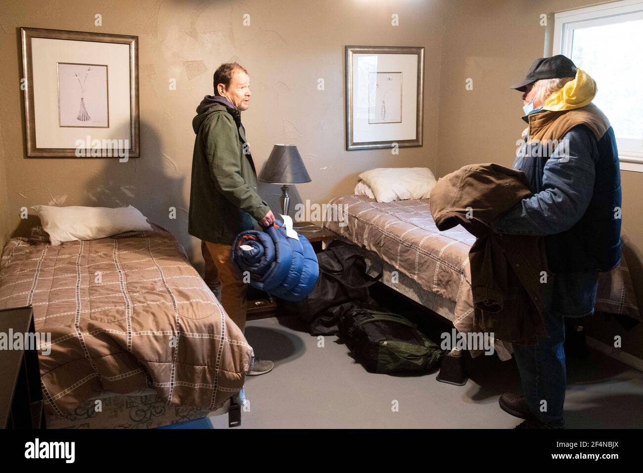Austin, TX USA Feb 20, 2021: Homeless veterans arrive for their first night at a privately-run sober house after spending a week at a church-run warming shelter during Austin's recent severe winter weather. Church members arranged for the new accommodations after both men requested help for their alcoholism. Stock Photo