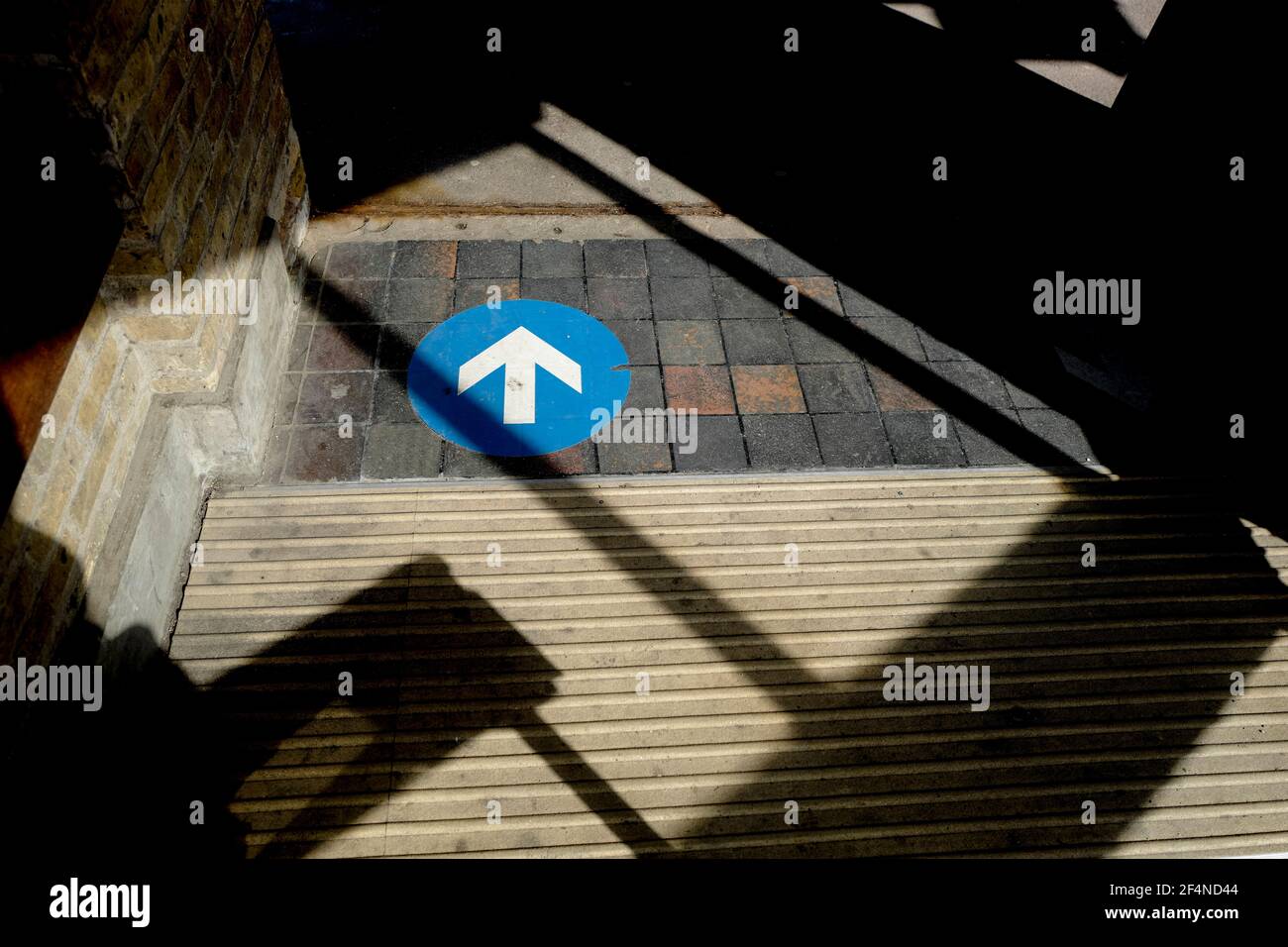 Arrow sign in shadows Stock Photo - Alamy