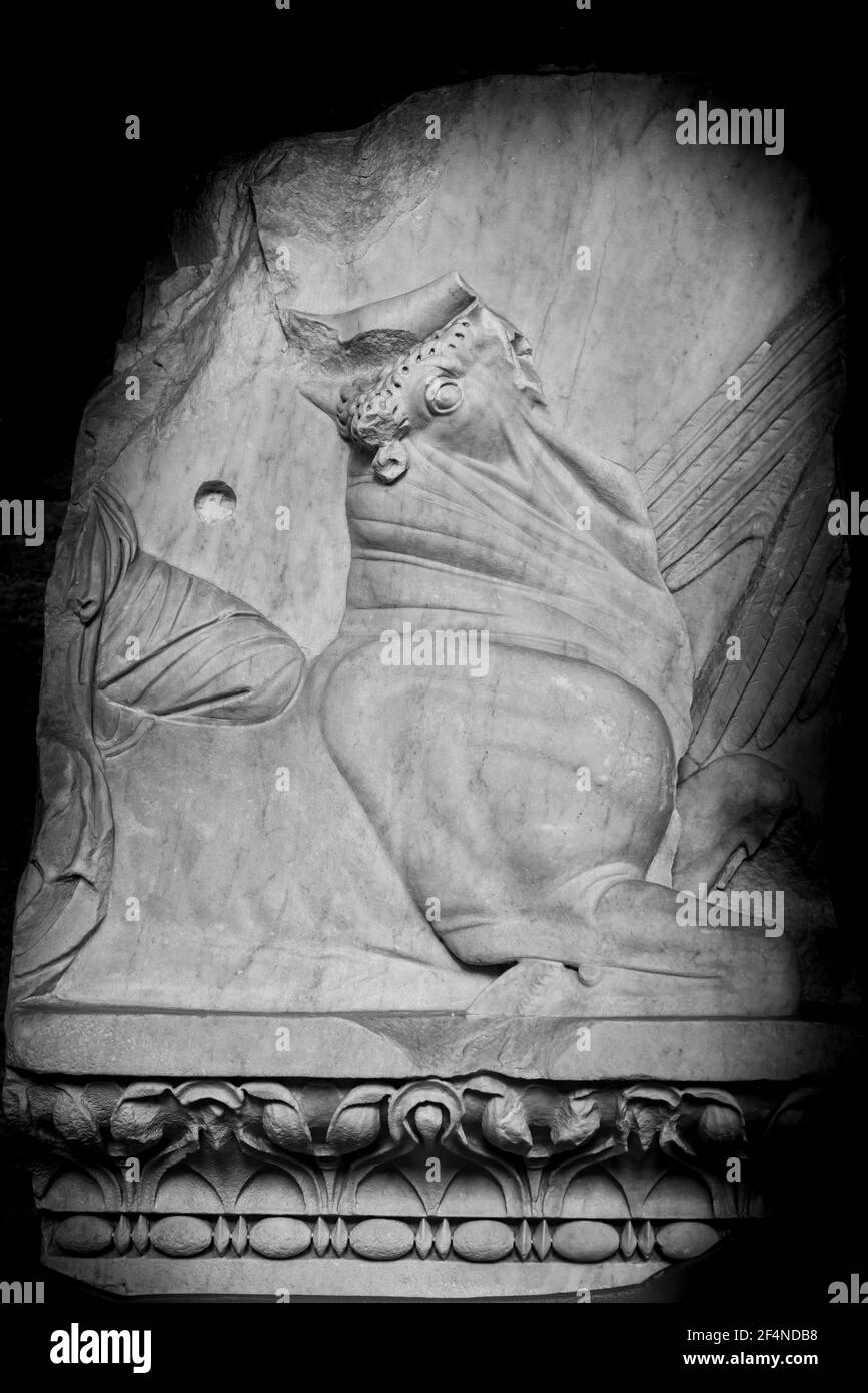 Black and white photo of mythical creature carved on ruins of ancient marble wall Stock Photo