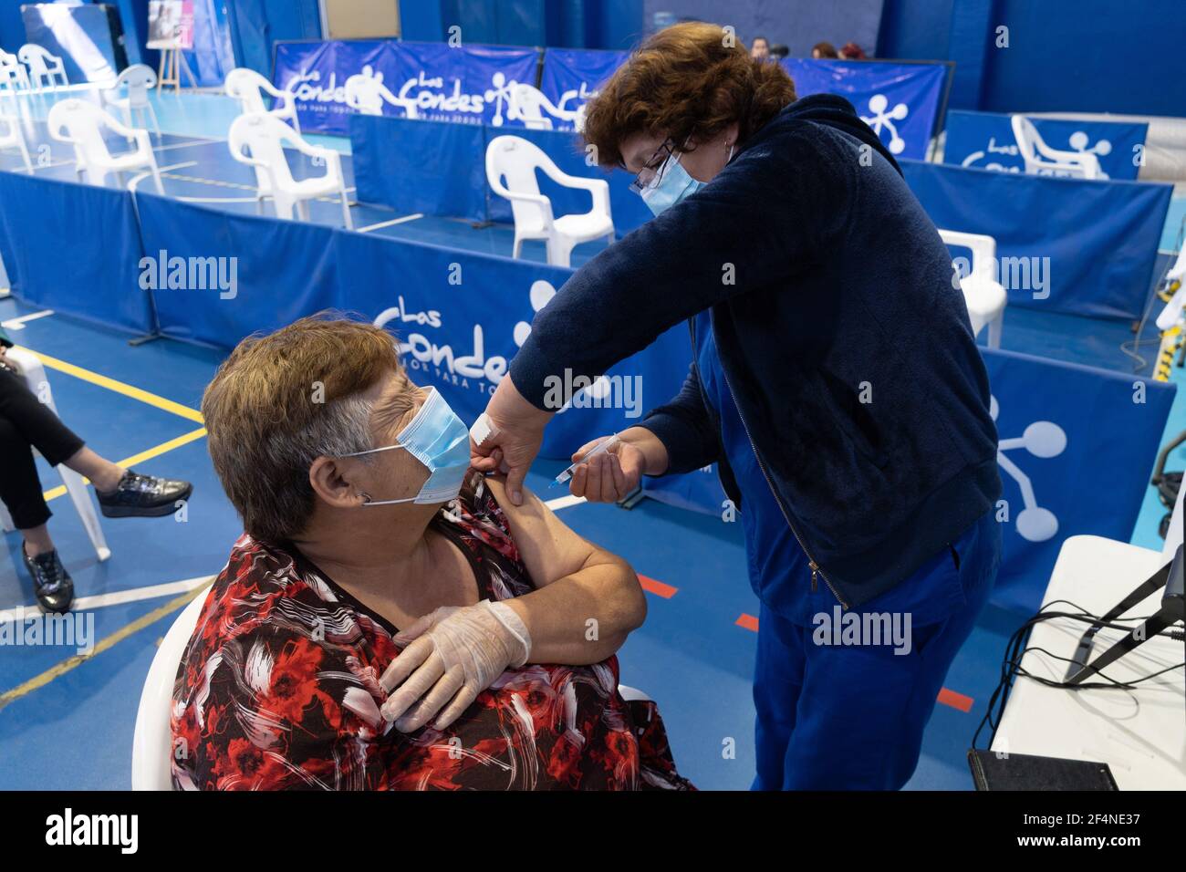 Santiago, Metropolitana, Chile. 22nd Mar, 2021. A woman receives a dose of the Sinovac vaccine, in a municipal stadium transformed into a vaccination center against covid in Santiago de Chile. Credit: Matias Basualdo/ZUMA Wire/Alamy Live News Stock Photo