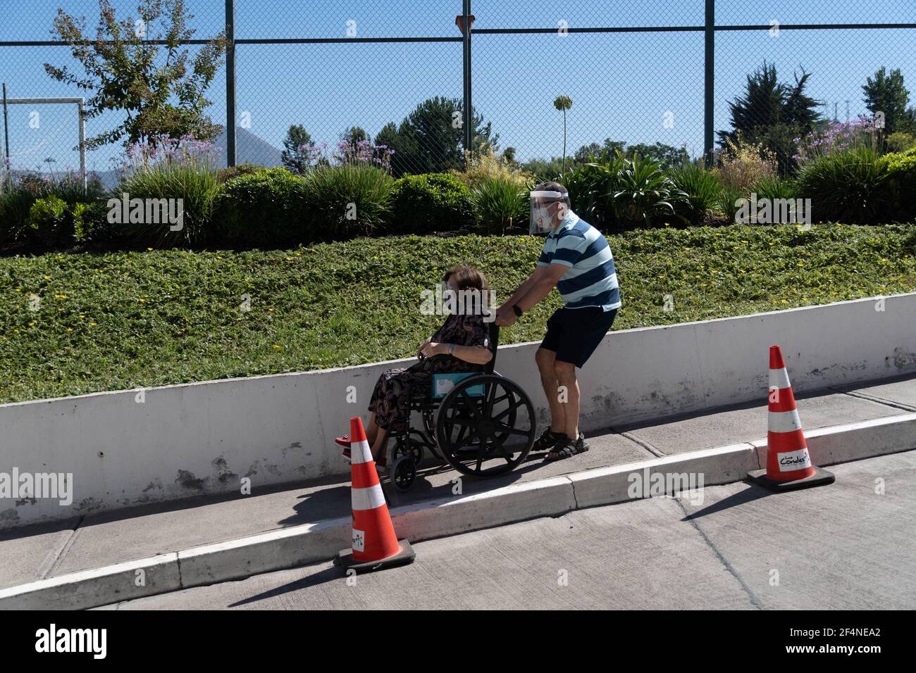 Santiago, Metropolitana, Chile. 22nd Mar, 2021. A man takes his mother to get vaccinated against covid, in a municipal stadium transformed into a vaccination center in Santiago, Chile. Credit: Matias Basualdo/ZUMA Wire/Alamy Live News Stock Photo