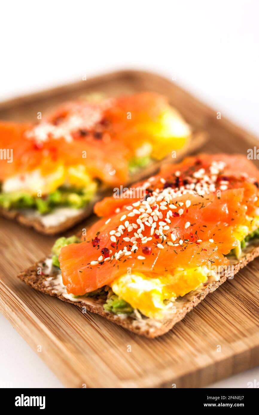Salted salmon, scrambled eggs, avocado and cream cheese rye crisp toast Stock Photo