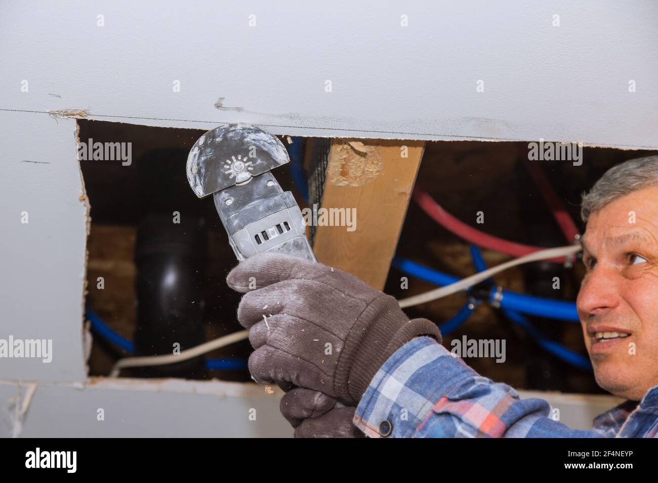 Maintenance repair works of replacement damaged drywall on worker
