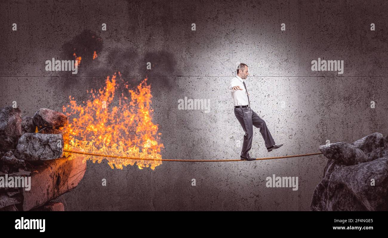 businessman walks in balance on a burning rope. danger concept. Stock Photo